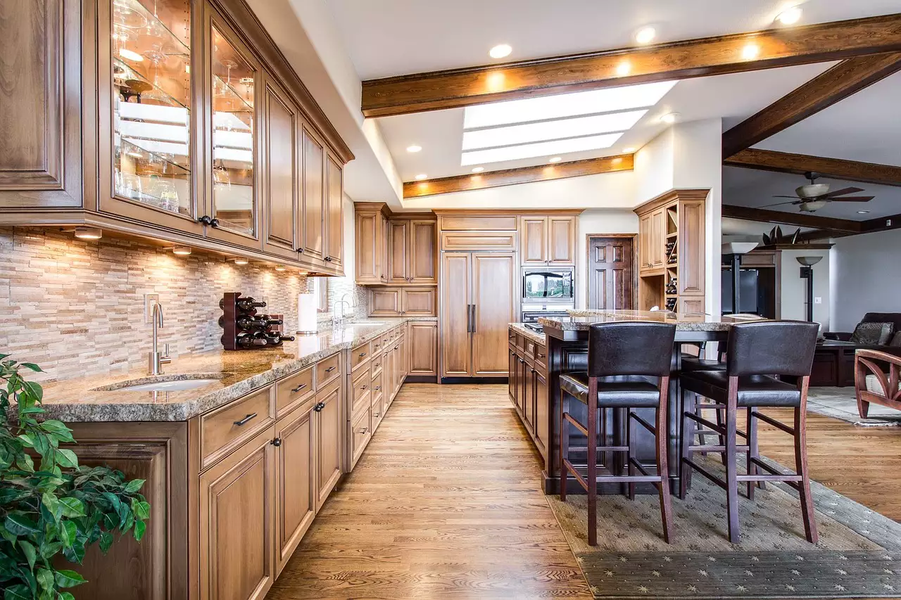 A finished kitchen with wood cabinets, ceiling beams and a skylight